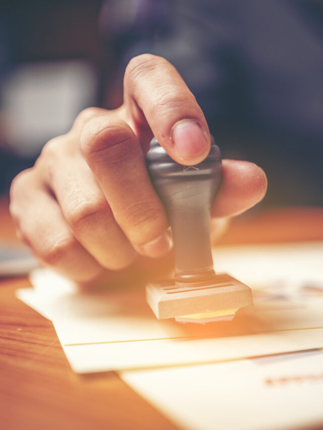 Close-up hand stamping of businessman for signing approval on documents , business concept