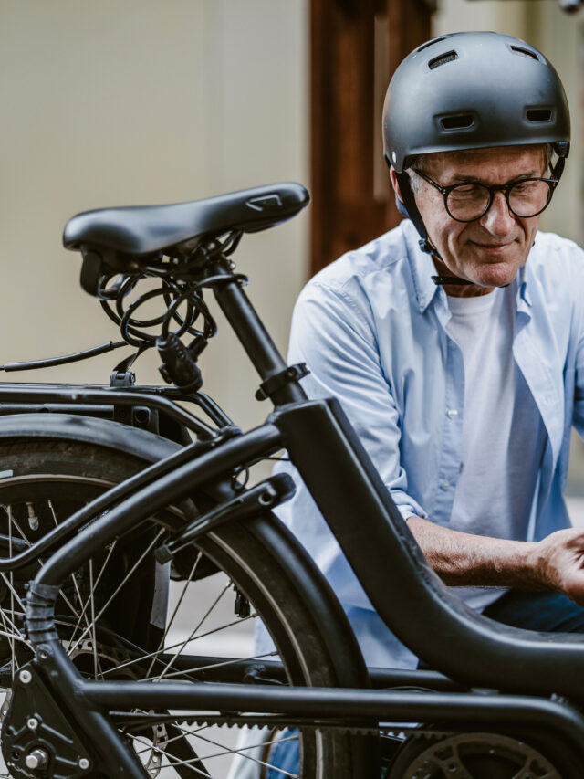 Senior man changing battery on electric bicycle