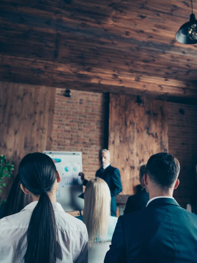 Crowd of nice stylish trendy serious sharks audience attending corporate forum listening top management company ceo boss chief specialist expert at industrial loft interior work place space indoors